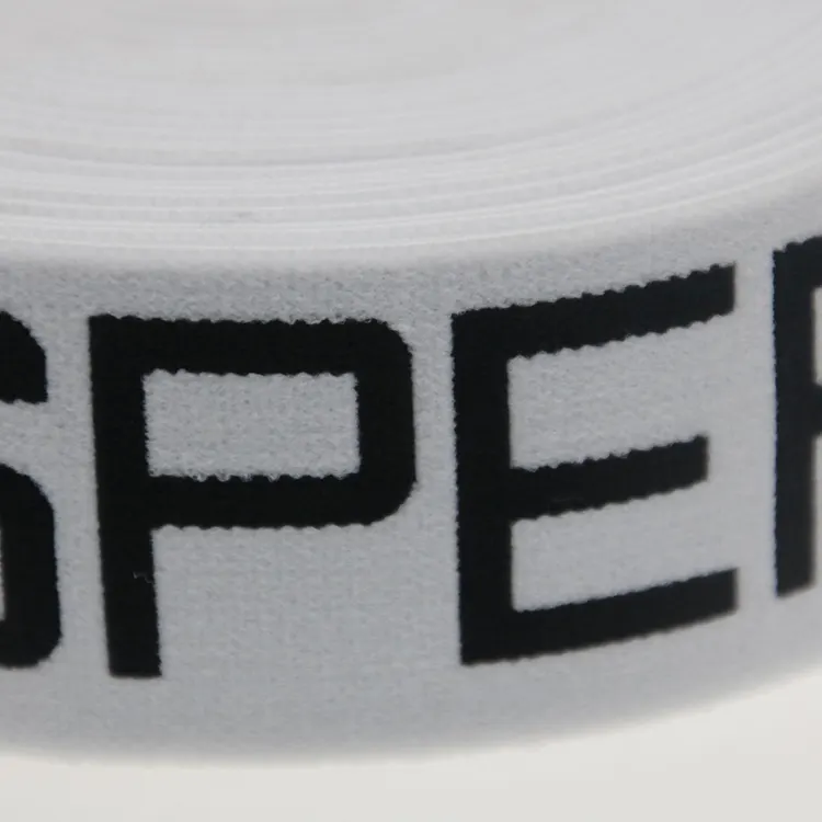 Close-up of black jacquard lettering woven into white elastic webbing