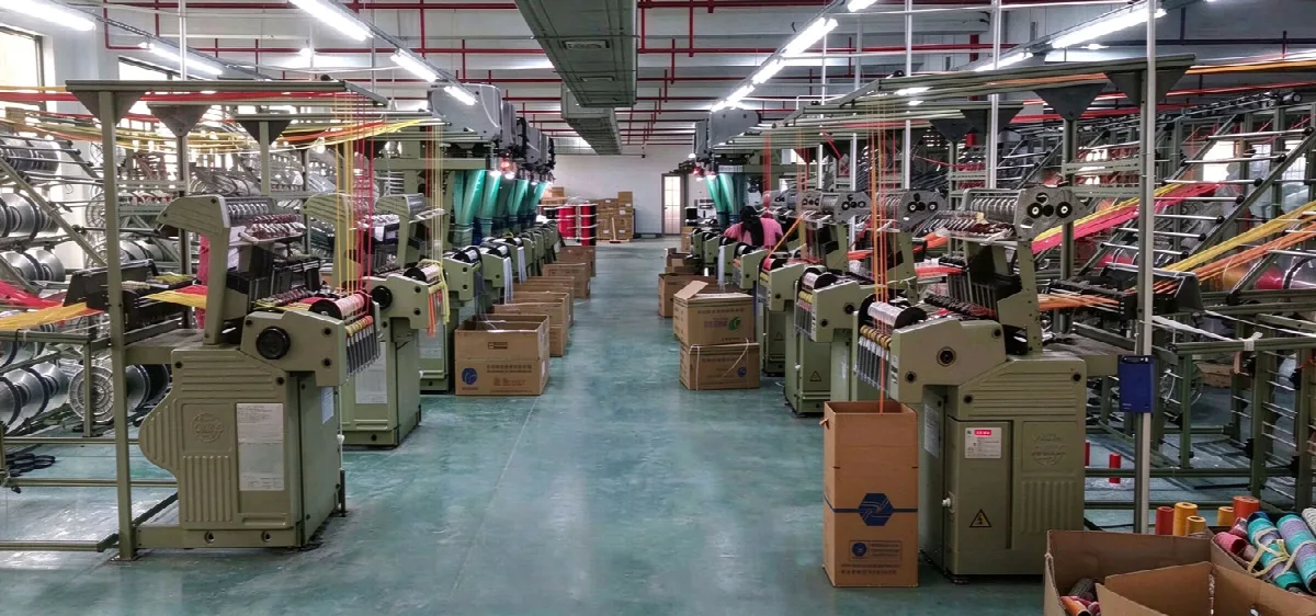 Panoramic view of the weaving workshop with rows of looms and colorful yarns