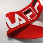 Red knitted webbing folded to show the printed white and black logo detail