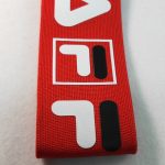 Red knitted webbing printed with white and black geometric logo shapes
