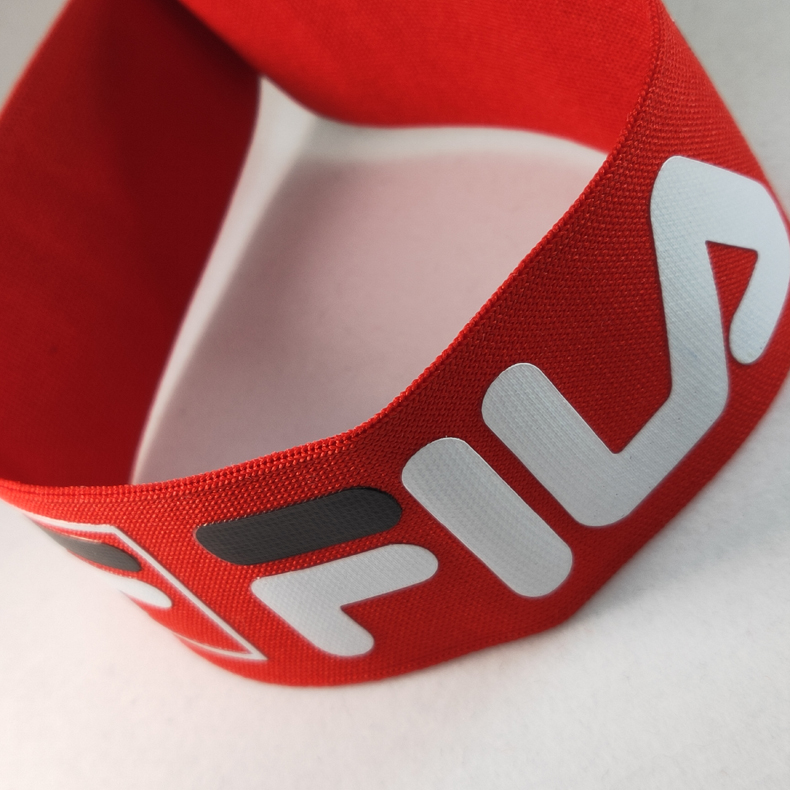 Looped red knitted webbing showing printed white logo and black graphic details