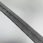 Close-up of grey buttonhole elastic tape showing the buttonhole openings and woven structure