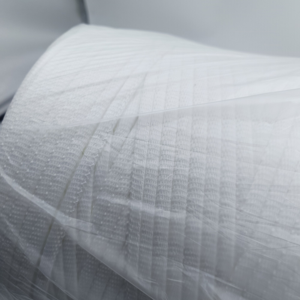 Close-up of white woven sealing strip material with a visible grid texture, partially covered by clear plastic film