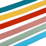 Six elastic binding tapes in teal, mustard yellow, red, dusty pink, sage green and sky blue on a white background